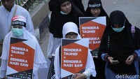Tak sedikit dari massa yang hadir membawa beragam atribut, mulai dari bendera merah putih, bendera Palestina hingga bendera tauhid.