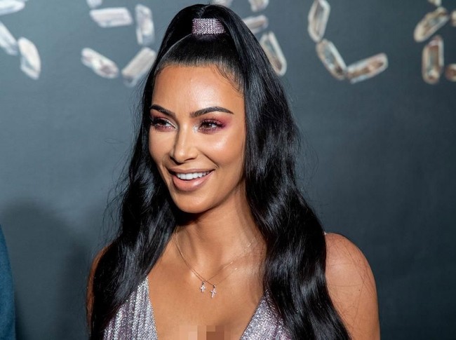 Untuk makeup, Kim Kardashian memilih tampilan minimalis dengan aksen warna di area kelopaka mata. Rambutnya dikuncir di atas sehingga terlihat mirip karakter Jinny si jin seksi. (Foto: Getty Images)