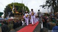 Selanjutnya pusaka tersebut diarak dibawa dengan cara digendong (diais) oleh para keturunan Raja Panjalu dan warga terpilih. Pusaka lalu diarak diiringi dengan solawat dan alat musik gembyung menuju Nusa Gede. (Dadang Hermansyah/detikTravel)