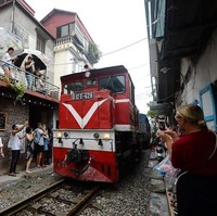 Kereta pun cukup sering lewat. Bukannya menghindari, banyak orang justru menunggu di samping rel untuk kereta itu lewat dan mengabadikan momennya. Foto: AFP