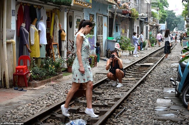 Kawasan Old Quarter, Vietnam memang menjadi atraksi para turis. Meski berlokasi di dekat rel kereta api itu dipenuhi beragam cafe. Tempat itu pun jadi semakin ramai karena mereka yang ingin mengambil foto stylish di tengah rel. Foto: AFP