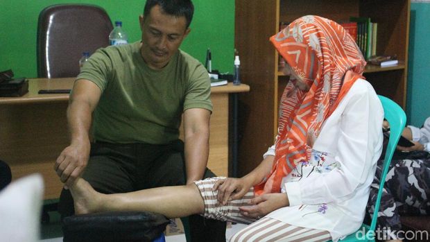 Kapten Tatang mengalirkan listrik ke tubuh pasiennya untuk meredakan berbagai keluhan.