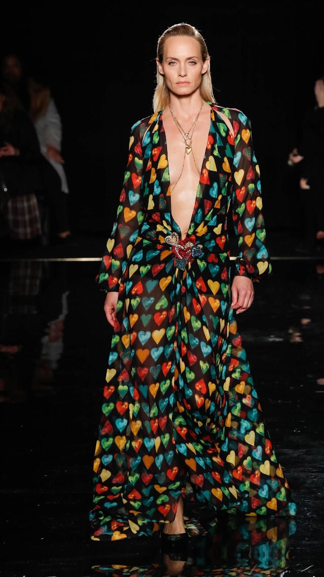 Turut muncul model senior sekaligus aktris Amber Valletta. Perempuan 44 tahun itu mencuri perhatian dengan gaun model kaftan bermotif hati. Garis leher bergaya belahan dada rendah pun mempertegas keseksian sang model. (Foto: Getty Images)