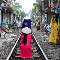 Turis lokal maupun mancanegara antre untuk mengambil gambar di tengah rel kereta api. Selayaknya pemotretan, beberapa di antara mereka bahkan mempersiapkan busana spesial seperti para wanita yang mengenakan pakaian tradisional ini. Foto: AFP