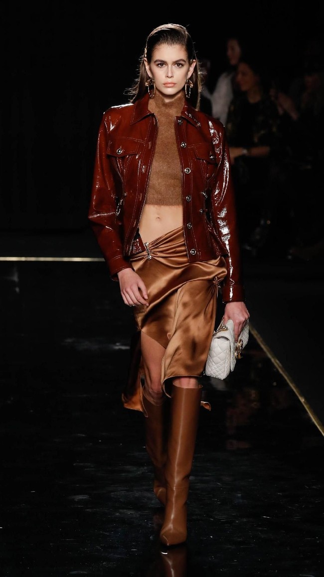 Kaia Gerber juga eksis di peragaan yang dihadiri deretan selebriti ternama itu. Putri dari supermodel senior Cindy Crawford itu tampil dengan turtle-neck cropped top yang mengekspos perut ratanya, serta jaket kulit marun dan rok asimetris. Tidak ketinggalan boots tinggi dan handbag putih. (Foto: Getty Images)