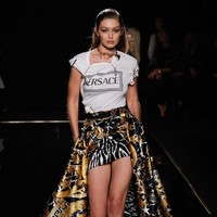 Gigi Hadid on action! Kakak dari Bella Hadid ini menebar pesonanya dalam padanan gaya urban yang terdiri dari kaus berikut rok mini dengan ekor panjang dan sneakers. (Foto: Getty Images)