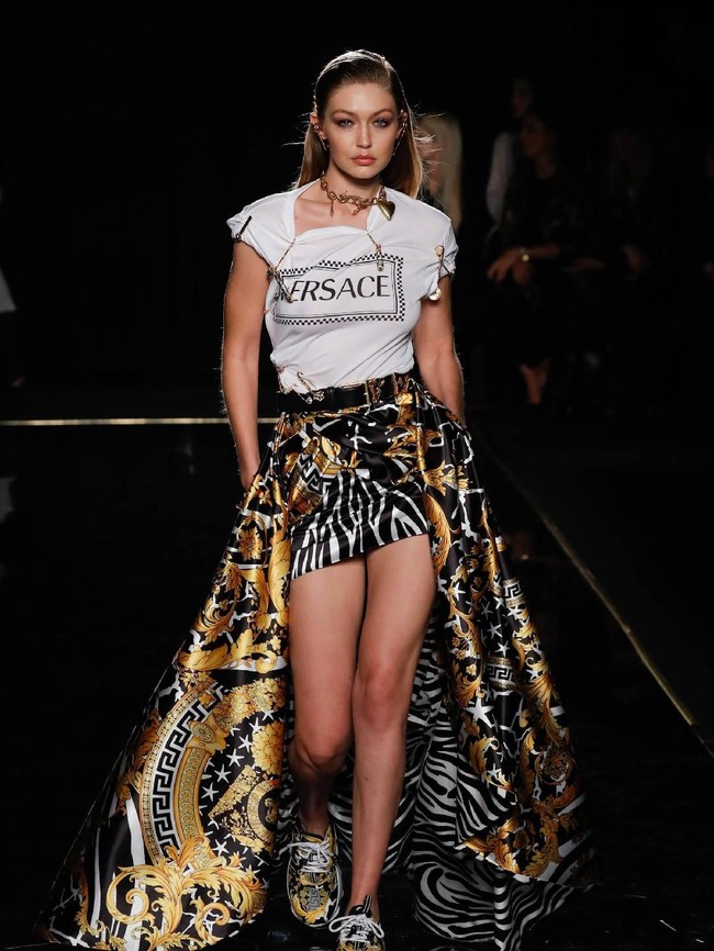 Gigi Hadid on action! Kakak dari Bella Hadid ini menebar pesonanya dalam padanan gaya urban yang terdiri dari kaus berikut rok mini dengan ekor panjang dan sneakers. (Foto: Getty Images)