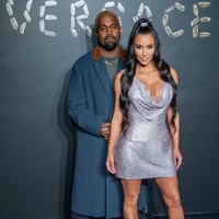 Kanye mengandalkan gaya vintage dengan oversized coat yang dipasangkan dengan sneakers abu-abu sehingga terasa kekinian. (Foto: Getty Images)