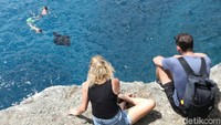 Sepasang turis asing yang tengah asyik melihat aktivitas snorkeling dari kejauhan (Agung Pambudhy/detikTravel)