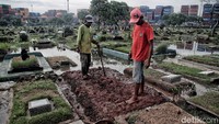 Walaupun banjir, beberapa petugas masih menyelesaikan pengerjaan makam.