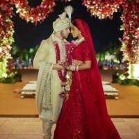 Dalam foto lain, istri Nick Jonas tersebut juga terlihat memakai busana tradisional India yakni choli dan lehenga berwarna merah yang dipadukan dengan dupatta berdetail renda sebagai penutup kepala. Baju tersebut pun terlihat glamour dengan materialnya yang gemerlapan. Sedangkan Nick memakai sherwani emas dengan turban berbulu. Foto: Instagram @priyankachopra