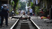 Ada juga traveler yang berpose nyeleneh, seperti satu ini yang sedang planking di atas rel. Rel kereta ini memang cukup bersejarah karena dibangun pada masa penjajahan kolonial Prancis. (AFP/Getty Images)