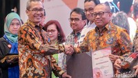 Wakil Ketua KPK Alexander Marwata (kiri) memberikan apresiasi kepada Dirut BPJS Ketenagakerjaan Agus Susanto (kanan) karena telah mengelola dan mengendalikan gratifikasi dengan baik diperusahaan yang dipimpinnya.   