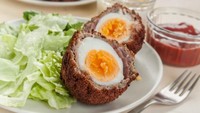 Scotch Eggs adalah telur ayam rebus yang dibalut adonan daging. Kemudian dilapisi tepung roti dan digoreng kering. Untuk menyantapnya dibelah dua. Kadang diberi saus kadang tidak. Sajian telur khas Inggris ini biasa dinikmati untuk sarapan atau makan siang. Karena rasanya gurih enak maka disukai banyak orang. Foto: iStock