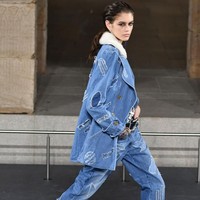 Selain Pharrell,  tampil pula model Kaia Gerber. Ia diberi mandat untuk memeragakan setenal denim yang menginjeksikan sentuhan urban di tengah dominasi busana bernuansa emas dan penuh detail beading ini. Foto: Dok. Getty Images