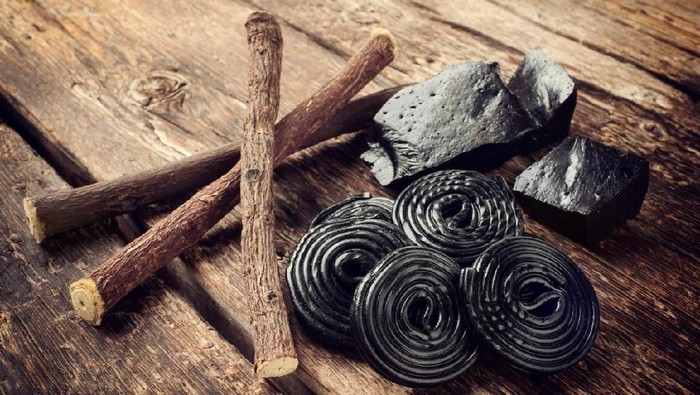 Production steps of licorice, roots, pure blocks and candy on wooden table
