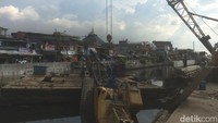 Sebelum lengan crane diangkat, petugas terjun ke Kali Jiung untuk melepaskan kabel-kabel di crane yang roboh (Foto: Rolan/detikcom)