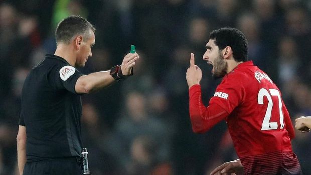 Marouane Fellaini diperingatkan wasit usai melakukan pelanggaran. (