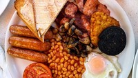 Orang Inggris benar-benar memulai hari dengan sarapan seperti Raja. Mereka menyebutnya ‘Full English Breakfast’. Satu sajian menu sarapan yang lengkap. Sajian ini terdiri dari bacon atau sosis goreng, telor mata ssapi, baked beans, tomat panggang, roti panggang dan kadang dilengkapi dengan kentang goreng atau jamur tumis. Foto: iStock