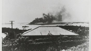Dari kejauhan, kapal tempur USS Arizona tampak mulai tenggelam setelah menjadi korban serangan dadakan Jepang ke Pearl Harbour. (Foto: Hulton Archive/Getty Images)