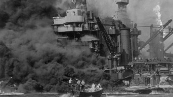 Sebuah perahu kecil berusaha membantu evakuasi korban selamat dari USS West Virgina yang terkena serangan militer Jepang di Pearl Harbour (Foto: Fox Photos/Getty Images)