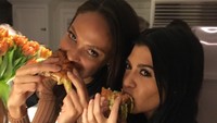 Makan burger ditemani sahabatnya, Kourtney terlihat bersemangat menyantap salah satu makanan kesukaannya. Foto: Instagram @kourtneykardash