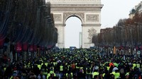 Massa berjalan dengan latar belakang Monumen Arc de Triomphe. REUTERS/Christian Hartmann.