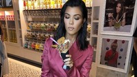 Wanita berusia 39 tahun ini tapi cantik dan awet muda dengan pakaian merah muda, serta es krim cone berlapis permen yang disukainya. Foto: Instagram @kourtneykardash