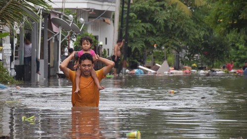 Seorang warga melintasi banjir saat mengevakuasi keluarganya di kawasan perumahan jalan Pura Demak, Denpasar, Sabtu (8/12/2018). Hujan deras yang mengguyur wilayah Bali selatan pada Sabtu dinihari menyebabkan sejumlah kawasan di Denpasar terendam banjir sehingga sejumlah warga dievakuasi. ANTARA FOTO/Adhi Prayitno/nym/hp.