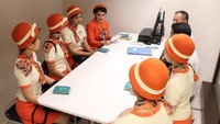 Pramugari mengenakan seragam bernuansa oranye, lengkap dengan topinya (dok Garuda Indonesia)