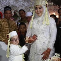 Daus Mini juga terlihat mengusung adat Betawi untuk pernikahan ketiganya dengan Selviana Hana Wijaya. Dalam foto Daus dan Selvi tampil kompak mengenakan busana pernikahan adat Betawi berwarna merah. Foto: Trans7 Official
