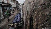 Air laut mengalir dari retakan tanggul di Muara Baru, Jakarta Utara, Senin (10/12/2018).