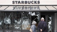 Kaca jendela Starbucks pecah dihajar massa. REUTERS/Piroschka van de Wouw.