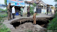 Salah seorang pegawai Pemkab Kabupaten Bandung nampak memeriksa lubang besar di Jalan Kutawaringin.