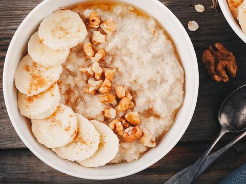 healthy breakfast bowl. oatmeal with banana, walnuts, chia seeds and honey on wooden background