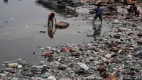 Sejumlah anak bermain di pantai yang penuh oleh sampah plastik.