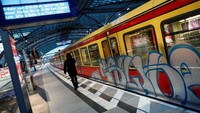 Seorang penumpang berjalan di depan kereta kota S-Bahn dari Deutsche Bahn. Fabrizio Bensch/Reuters.