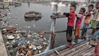 Sejumlah anak bermain di rumah apung yang di bawahnya dipenuhi oleh sampah plastik.