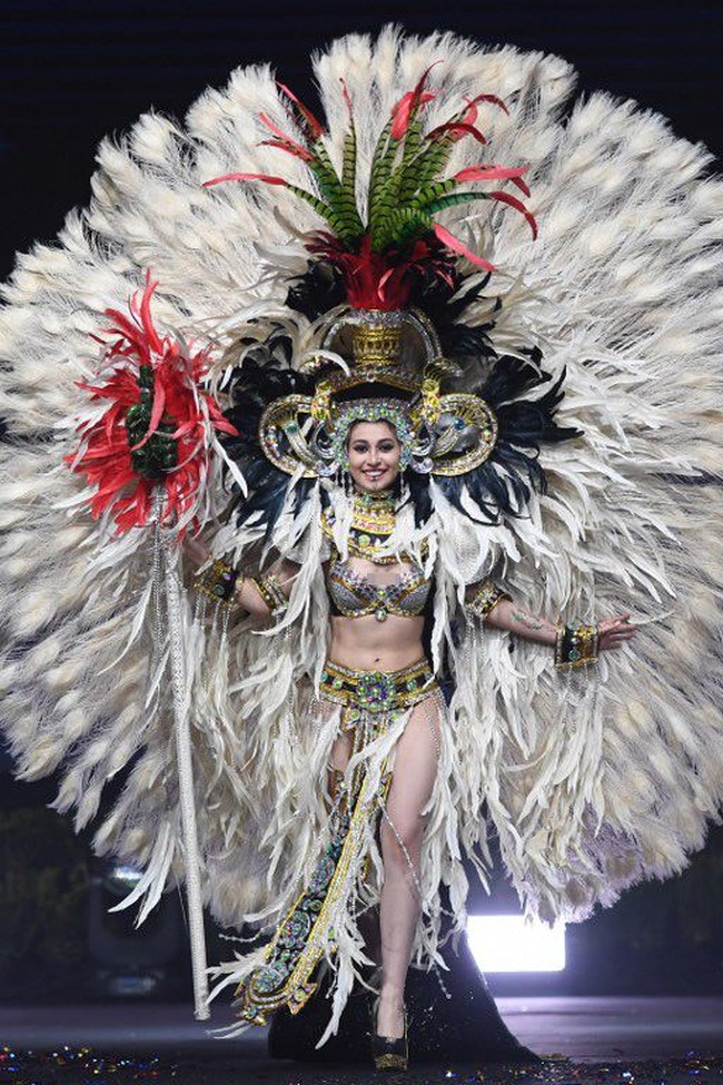Miss Guatemala 2018 Mariana Garcia bergaya seksi dalam kostum nasionalnya. Busana Mariana begitu heboh dengan hiasan bulu berwarna putih ukuran besar. Dalam akun Instagramnya, wanita cantik ini mengatakan kalau kostumnya terinspirasi dari Suku Maya. Foto: Lillian SUWANRUMPHA / AFP