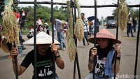 Aksi teatrikal turut ditampilkan dalam demo tersebut. Dua orang petani nampak terkurung dijeruji besi karena menolak dan mempertahankan lahan mereka.