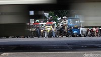 Pemotor yang tertib menunggu kereta melintas agar aman.