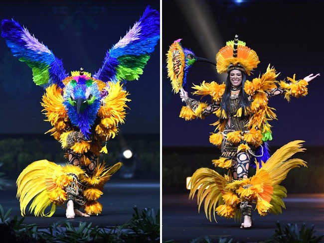 Kostum nasional Miss Brazil 2018 Myra Dias paling banyak dijagokan menang di Miss Universe 2018. Dalam sesi penjurian, Mayra tampil mengenakan kostum yang dinamai Deusa Do Sol. Kostum tersebut dibuat untuk menghormati suku asli Brazil. Dalam balutan kostum berwarna kuning itu Mayra memberikan kejutan di akhir penampilannya di mana dia menjelma menjadi burung. Foto: Lillian SUWANRUMPHA / AFP