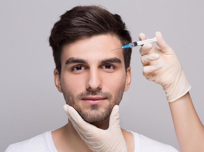 Filler forehead injection for male face in beauty clinic