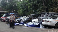 Polisi nampak berjaga di sekitar mobil-mobil yang akan dievakuasi.