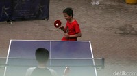 Orang dewasa hingga anak-anak nampak asyik bermain tenis meja di Pasar Grogol.