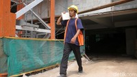 Para pekerja hilir mudik menyiapkan material bangunan.