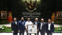 Anies Baswedan menerima karikatur dari Afifuddin Suhaeli Kalla.
