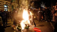 Massa yang terdiri dari ribuan para pekerja menggelar aksi unjuk rasa di depan gedung Parlemen Hungaria di kota Budapest, Kamis (13/12/2018) waktu setempat.