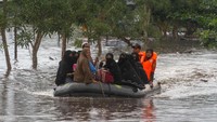 Petugas Basarnas menggunakan perahu karet mengevakuasi santri dan santriwati yang terjebak banjir di Pondok Pesantren Darul Ulum, Kecamatan Siak Hulu, Kabupaten Kampar, Riau, Rabu (12/12/2018). ANTARA FOTO/Rony Muharrman.