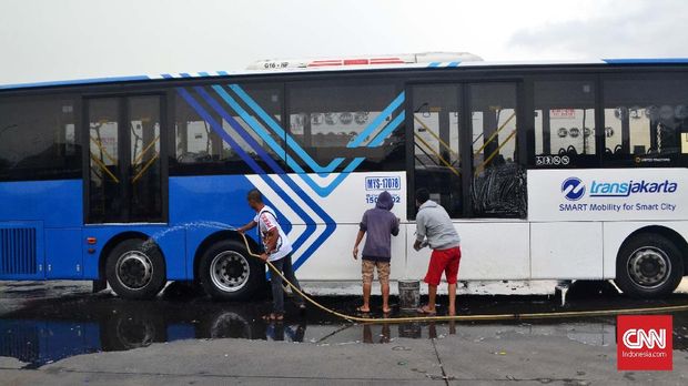 Para anggota Jakmania saling bantu membersihkan bus dari aksi vandalisme orang-orang tak bertanggung jawab. (